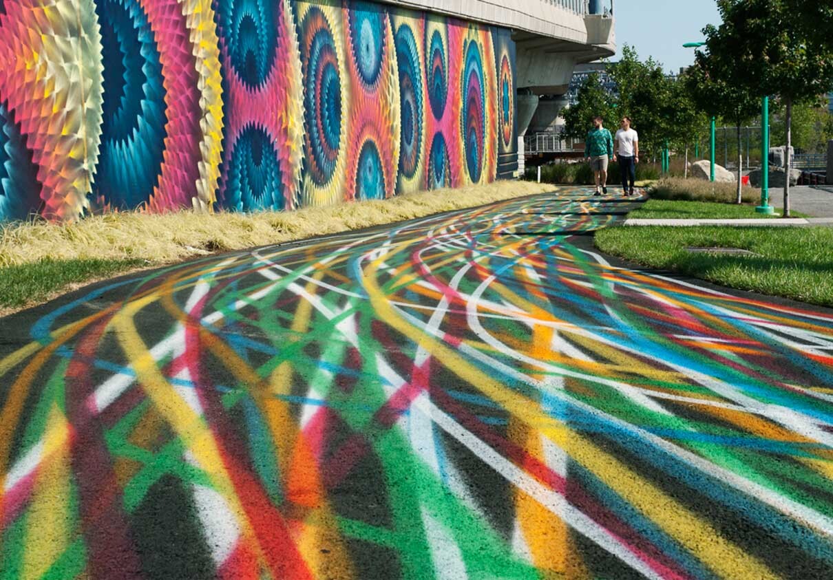 Large colorful mural on the side of the expressway